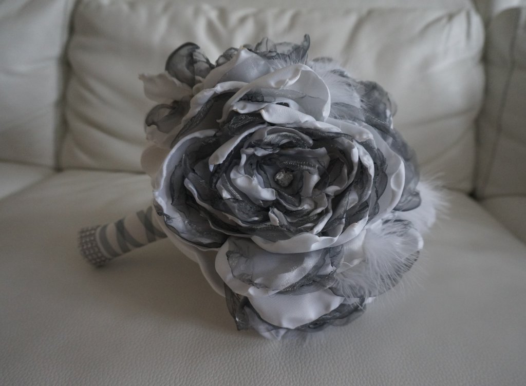 Bp 33
Bouquet de mariée en tissu et plumes pivoine
Organza gris et satin duchesse blanc
Fleur a pétales centre en strass et poignée strass
135€