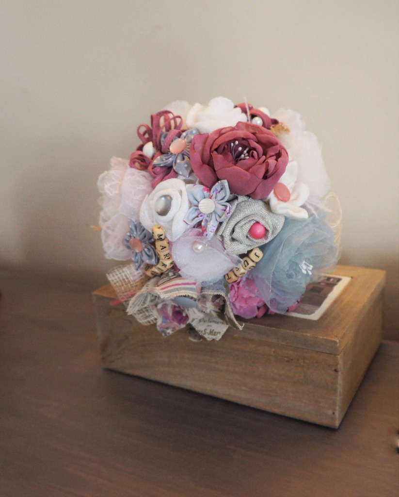 Bouquet de mariée rétro rose et gris
Un bouquet avec des matières différentes pouvant s'accorder a votre theme de mariage . Bouquet de mariée en lin ainsi que de l'organza et de la dentelle. Des fleurs confectionner a  la main. 19cm de diametre 160€