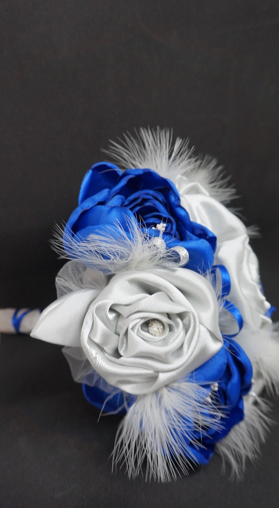 BP27
Bouquet de mariée bleu roi et argenté 
Roses fermés et roses à pétales ouverts , pistils et plumes
Perles strass, 23 cm de diamètre
139 €